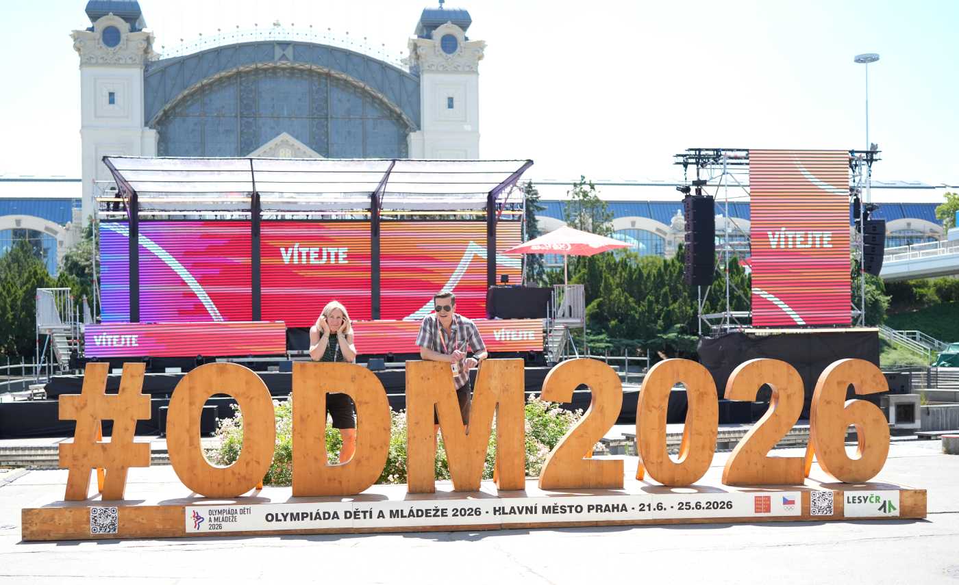 Dětský ombudsman stojí vedle své kolegyně za dřevěným nápisem ODM2026.